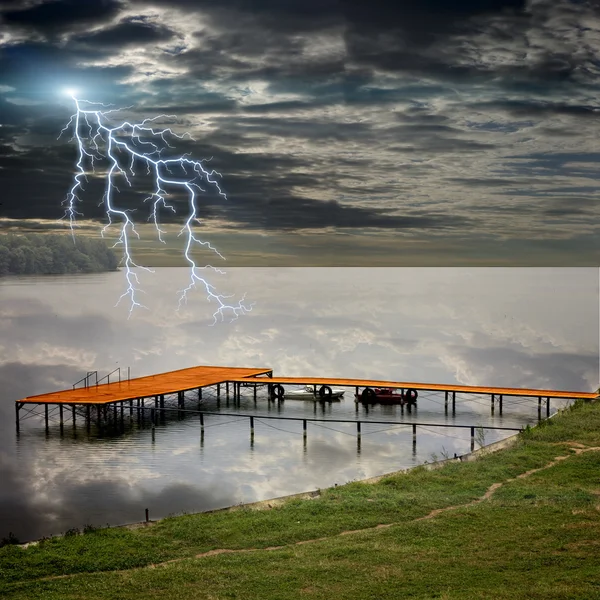 Stazione barca sul bellissimo lago e fulmini tempesta Foto Stock