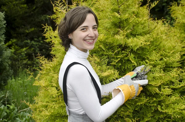 Mladá žena s zahradní nástroje při zahradničení — Stock fotografie