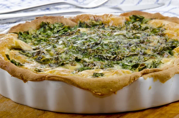 Spinach quiche in a porcelain baking form — Stock Photo, Image