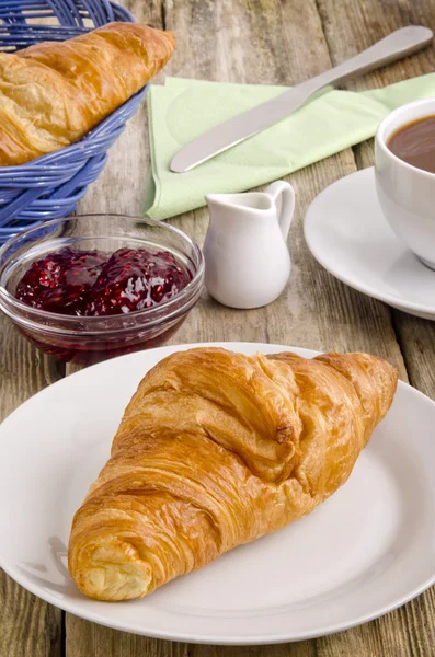 Croissant, a French breakfast, on a plate — Stock Photo, Image