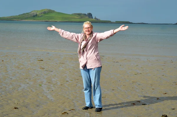 Счастливая женщина стоит на пляже — стоковое фото