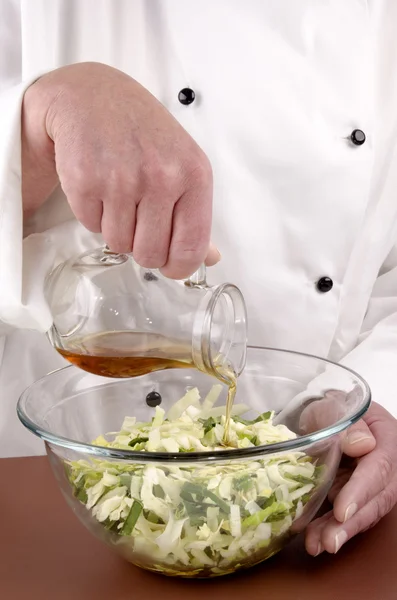 Chef gives oil to chopped savoy cabbage — Stock Photo, Image