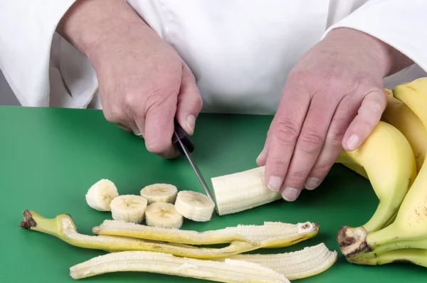 Ženské šéfkuchař řezání banán — Stock fotografie