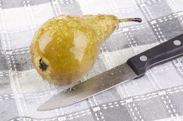 Een natte peer en een keukenmes — Stockfoto