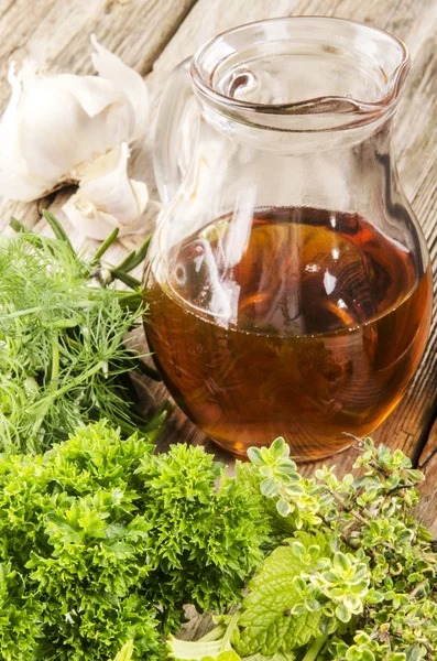 Varias hierbas aromáticas y una botella con aceite —  Fotos de Stock