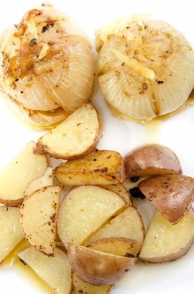 Rostad lök potatis på en vit platta — Stockfoto