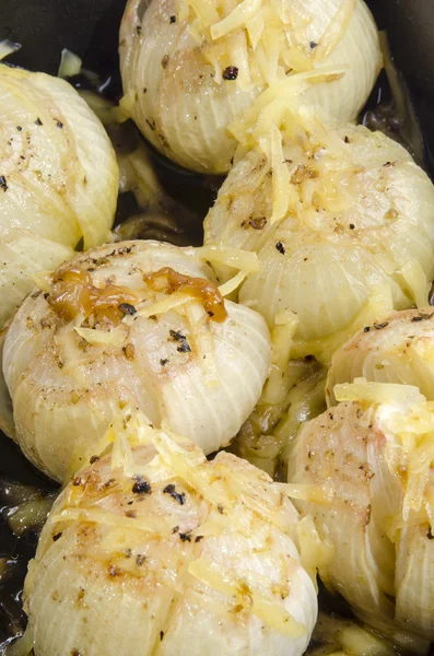 Roasted onion with spices in a black pan — Stock Photo, Image