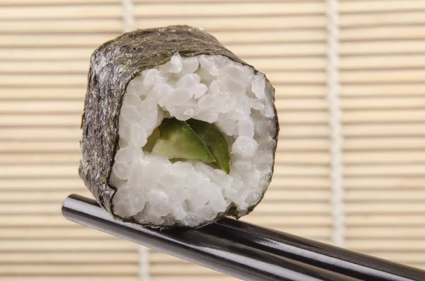 Sushi en en twee stokjes bruin — Stockfoto