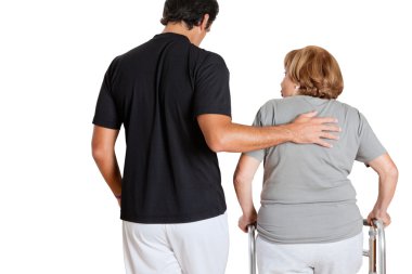 Trainer Assisting Senior Woman With Her Walker clipart