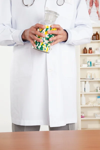 Лікар тримає пляшку з таблетками. — стокове фото