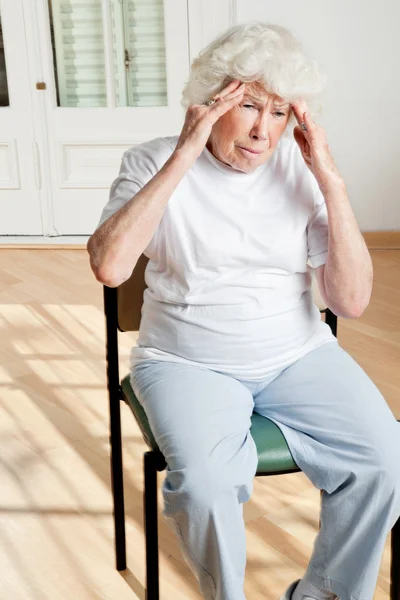 Пожилая женщина страдает от головной боли — стоковое фото