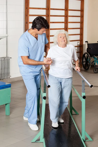 Terapeuta asistiendo a mujer mayor cansada en camino — Foto de Stock