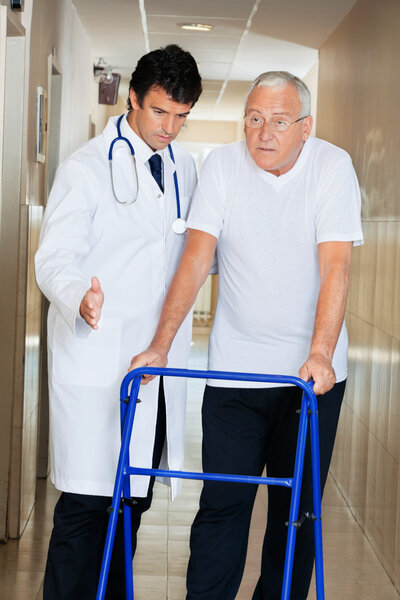 Doctor Assisting Senior Man On a Walker