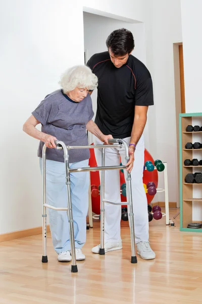 Trenér pomáhat starší žena v pohybu — Stock fotografie