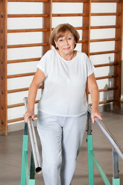 Mulher andando com a ajuda de barras de apoio — Fotografia de Stock