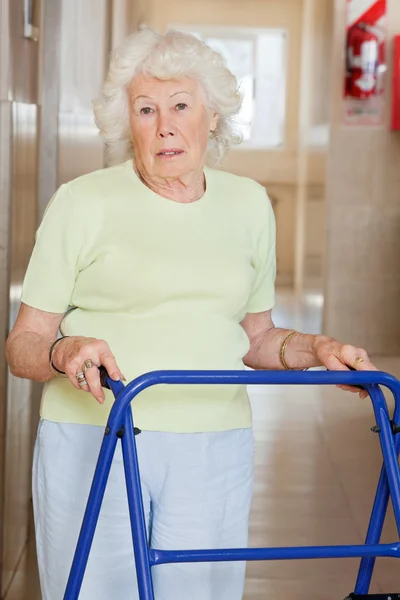 Senior vrouw met behulp van zimmer frame — Stockfoto