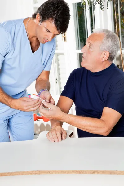 Male Nurse Checking Sugar Level Of Senior Man — Stock Photo, Image