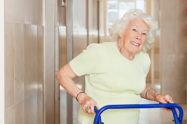 Mujer mayor feliz usando el marco Zimmer —  Fotos de Stock