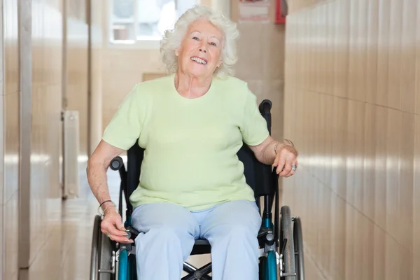 Счастливая пожилая женщина сидит в волосах на колесах — стоковое фото