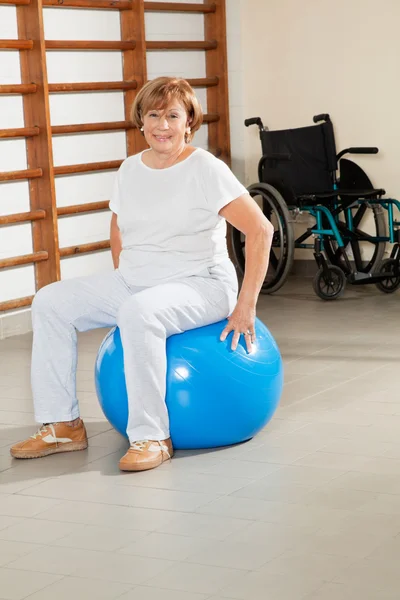 Donna anziana seduta sulla palla fitness — Foto Stock