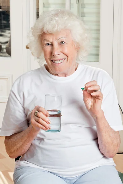 Женщина принимает лекарство — стоковое фото