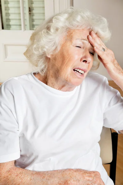 Yaşlı kadın baş ağrısı çekiyor. — Stok fotoğraf