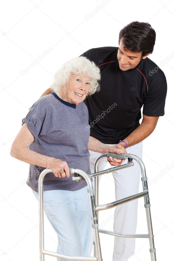 Senior Woman Holding Walker While Trainer Assisting Her