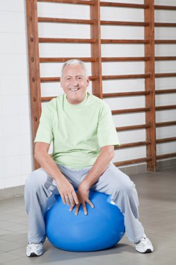 Senior Man Sits on a Fitball clipart