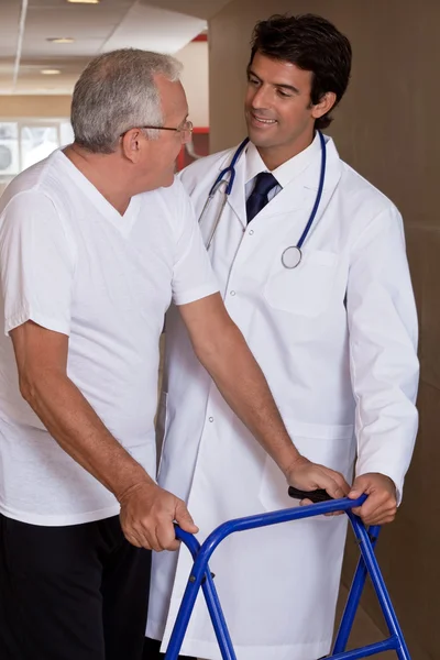Läkare att hjälpa patienten använda walker — Stockfoto