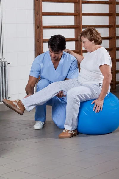 Fisioterapeuta ajudando um paciente — Fotografia de Stock