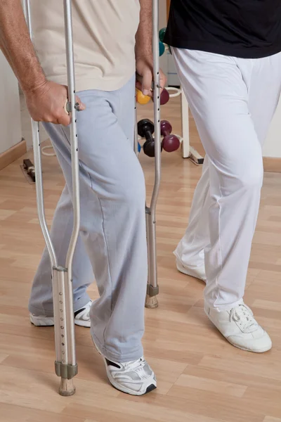 Paciente con muletas y médico — Foto de Stock