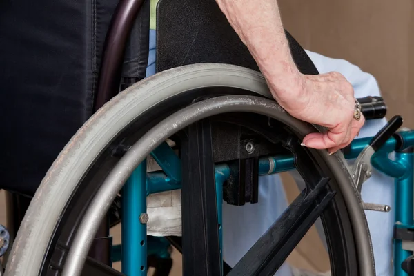 Les mains de la femme sur fauteuil roulant — Photo