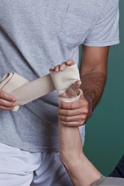 Terapeuta stosowania bandaż na rękę — Zdjęcie stockowe