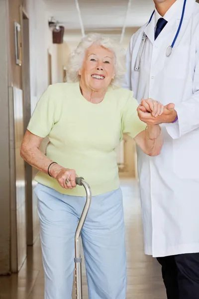 Доктор ассистирует пожилой женщине — стоковое фото