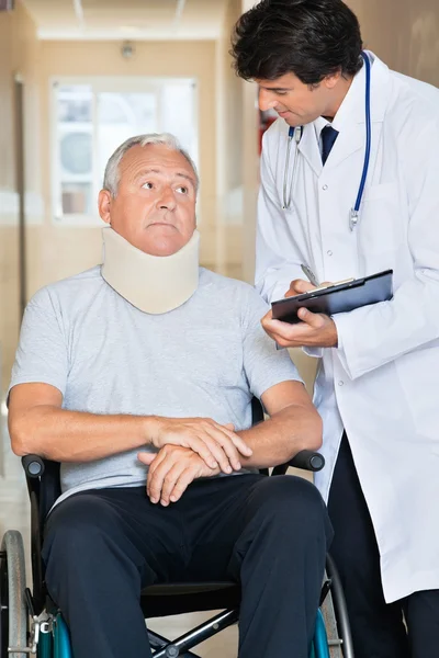 Médico comunicándose con el paciente en silla de ruedas — Foto de Stock