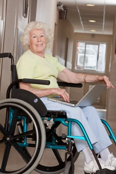 Kobieta na wózku przy pomocy laptopa — Zdjęcie stockowe