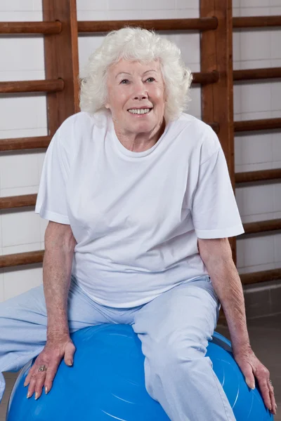 Starszy kobieta siedzi na fitball — Zdjęcie stockowe