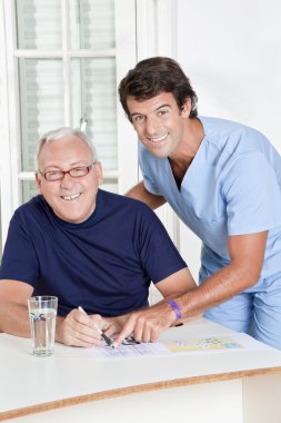 Mature Man playing Sudoku Puzzle clipart