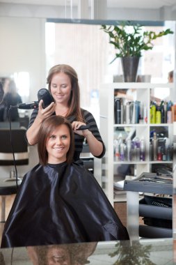 Stylist Drying Woman's Hair clipart