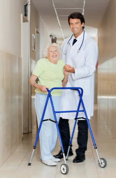 Médico ayudando a una anciana con su caminante —  Fotos de Stock