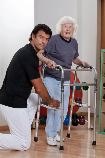 Terapeuta pomaga stosowania pacjenta Walkera — Zdjęcie stockowe