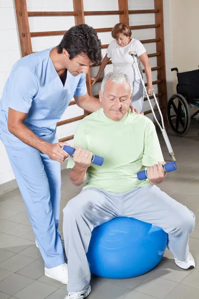 Fisioterapeuta ajudando um paciente — Fotografia de Stock