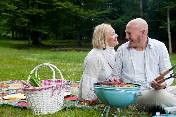 Couple heureux dans le parc avec barbecue — Photo
