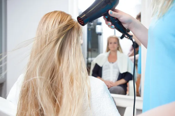 Estilista secado mujer cabello en salón de belleza — Foto de Stock