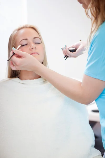 Vrouw toepassing van oogschaduw met borstel — Stockfoto