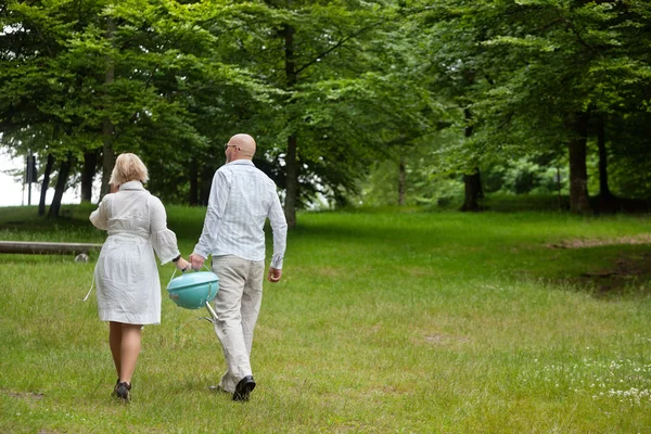Couple marchant avec barbecue portable — Photo