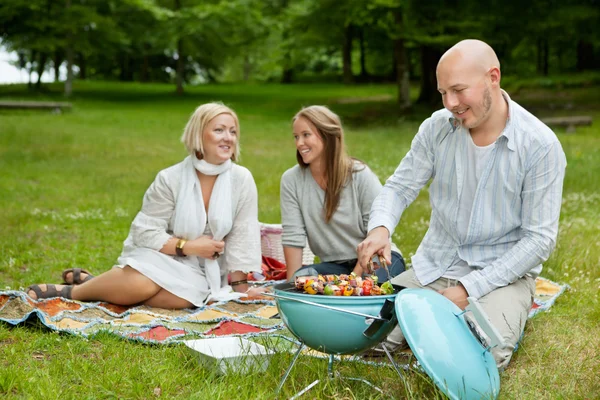 Amigos no parque comer churrasco Piquenique — Fotografia de Stock