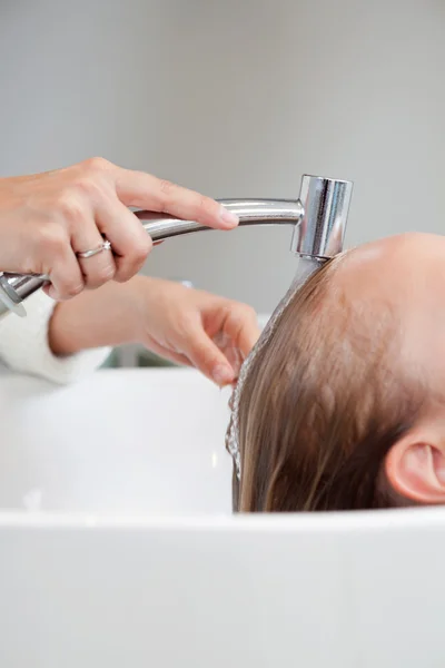 Frau lässt sich im Salon die Haare waschen — Stockfoto