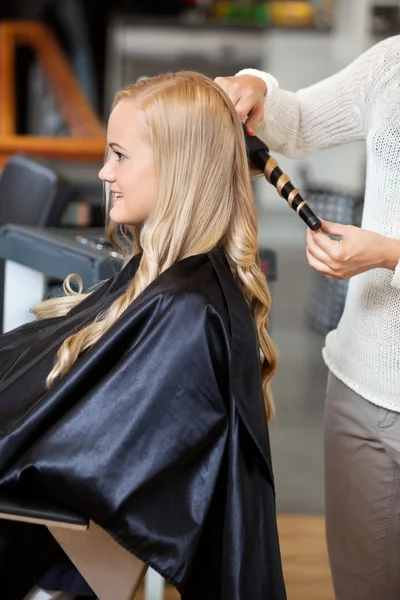 Mujer en el salón haciendo su pelo rizado —  Fotos de Stock