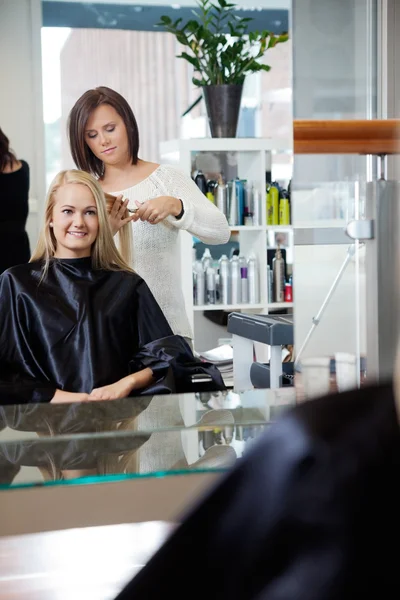 Frisör ger frisyr till kvinna — Stockfoto